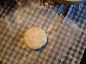Using the heat of your hands, and the paper as an aide, shape the dough into a disk. Resist the temptation to knead it, play with it, or work it too long. Don't worry if it cracks; just wrap it up and place it to rest in the refrigerator for at least 30 minutes and up to three days.